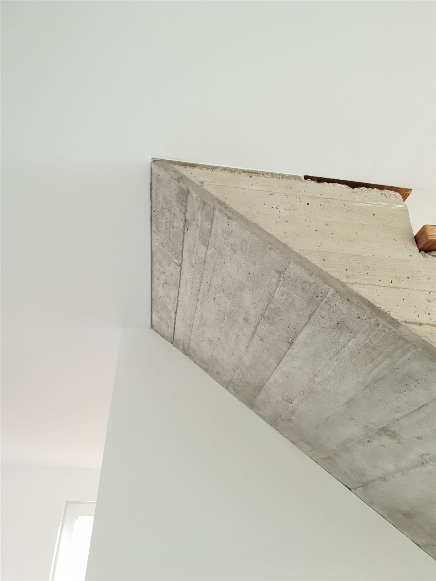 Untersicht eines fertigen Betontreppenlaufs mit sichtbarer Schalungsstruktur