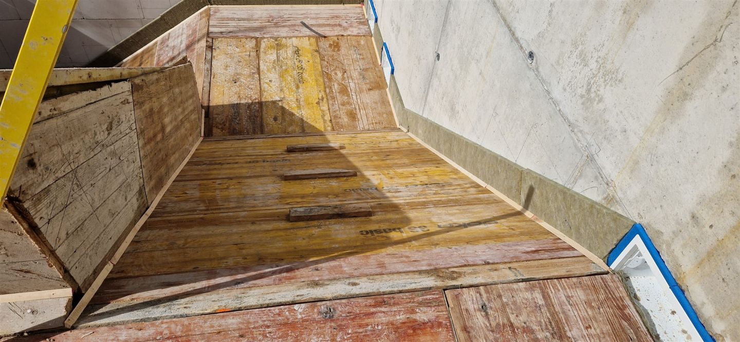 Aus Holz gezimmerte Schalung für einen Betontreppenlauf zwischen zwei Wänden
